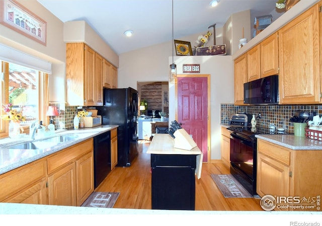 2707 Sedona Hills Dr, Loveland, CO 80537 - kitchen with lofted ceiling, sink, black appliances, a center island, and backsplash