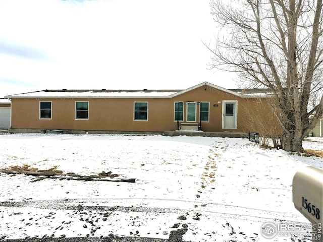 view of snow covered rear of property