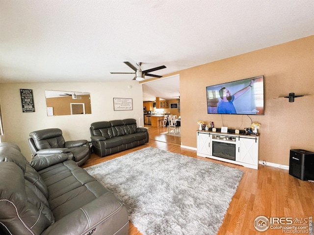 living room featuring wood-type flooring and ceiling fan