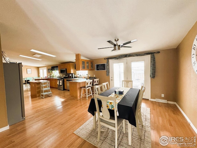 dining area with a textured ceiling, light hardwood / wood-style floors, and ceiling fan