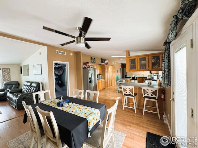 dining area featuring ceiling fan, lofted ceiling, and light hardwood / wood-style floors