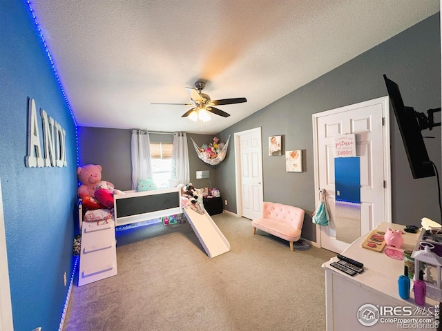 carpeted bedroom featuring ceiling fan, vaulted ceiling, and a textured ceiling