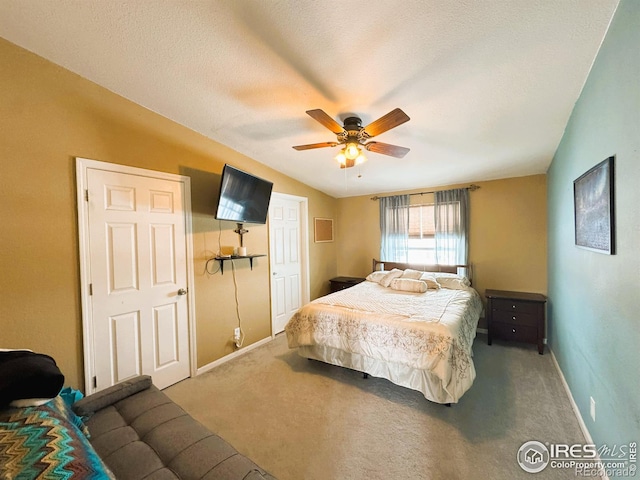 bedroom featuring vaulted ceiling, carpet flooring, ceiling fan, and a textured ceiling