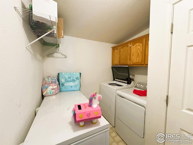 laundry area featuring cabinets, washer and dryer, and a textured ceiling