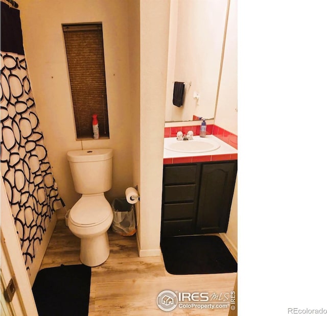 bathroom with vanity, hardwood / wood-style flooring, and toilet