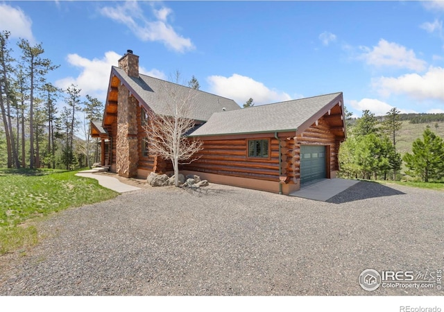 117 Crocus Dr, Bellvue, CO 80512 - log home featuring driveway, log exterior, a chimney, a shingled roof, and a detached garage