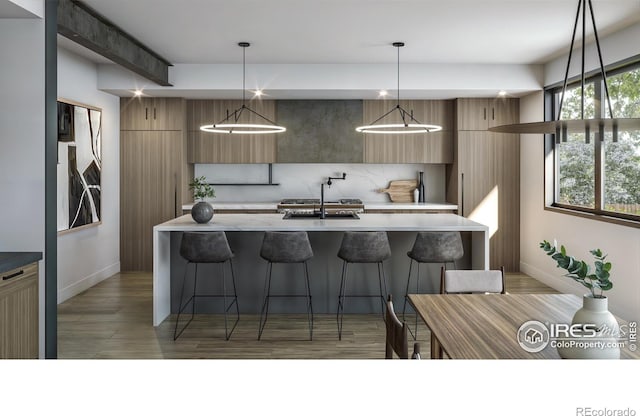 kitchen with pendant lighting, sink, decorative backsplash, and a breakfast bar area