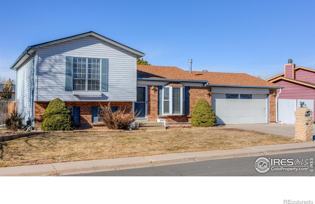 tri-level home with a garage and a front lawn