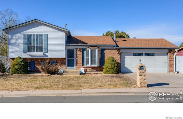 tri-level home with a garage and a front yard