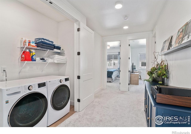 laundry room with light colored carpet and washing machine and dryer