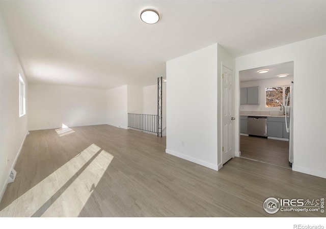 unfurnished room featuring sink, hardwood / wood-style floors, and a wealth of natural light