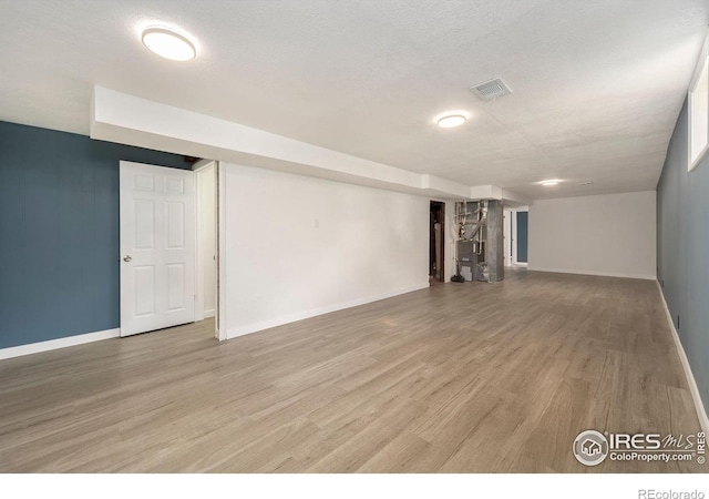 basement featuring hardwood / wood-style floors and a textured ceiling