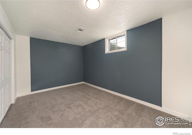 basement featuring carpet and a textured ceiling