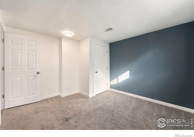 unfurnished bedroom featuring carpet and a textured ceiling