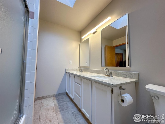 bathroom featuring vanity, toilet, and a skylight