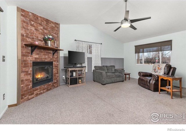 living room with vaulted ceiling, carpet, ceiling fan, and a brick fireplace