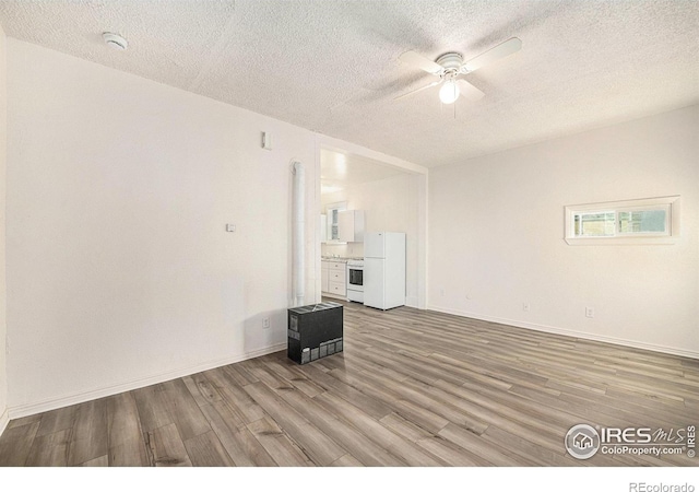 unfurnished living room featuring ceiling fan, wood-type flooring, and a textured ceiling