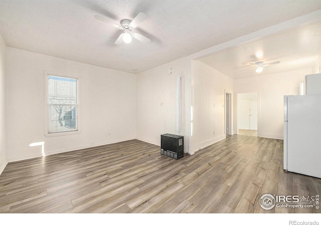 unfurnished room featuring a textured ceiling, wood-type flooring, and ceiling fan