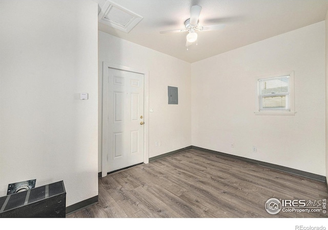 unfurnished room featuring ceiling fan, electric panel, and hardwood / wood-style floors