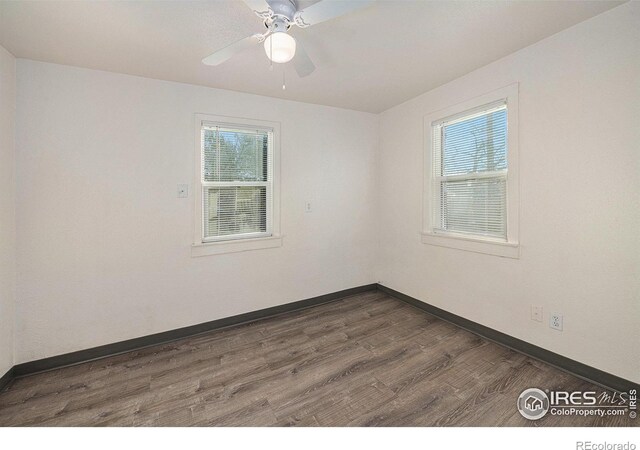 spare room with dark hardwood / wood-style floors and ceiling fan