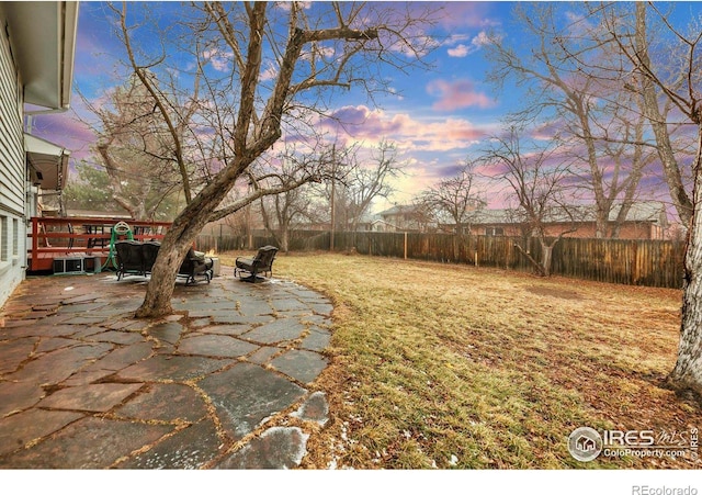 yard at dusk featuring a patio area