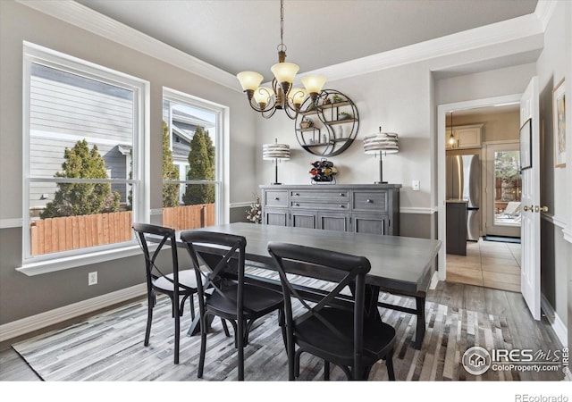 dining space featuring crown molding, wood-type flooring, and a chandelier