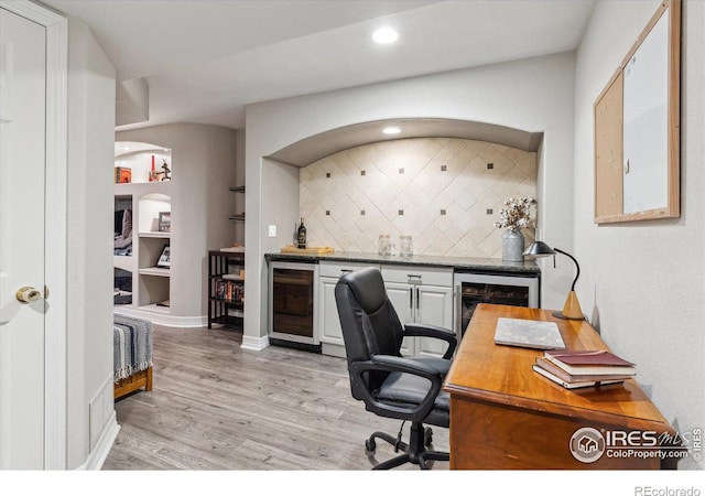 office space featuring wine cooler, bar, and light hardwood / wood-style flooring