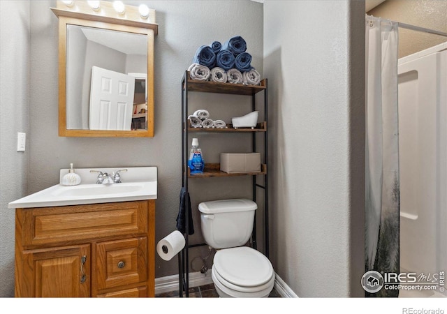 bathroom featuring vanity, toilet, and a shower with shower curtain