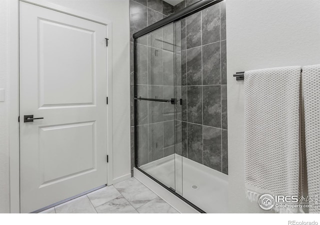 692 Galloway Dr, Johnstown, CO 80534 - bathroom featuring marble look tiles and a stall shower