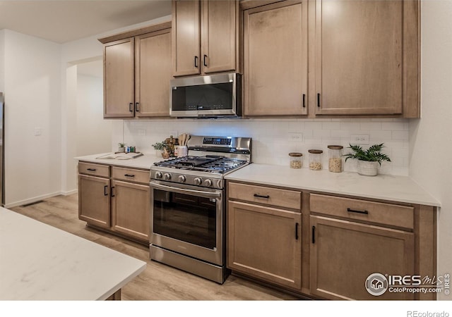 692 Galloway Dr, Johnstown, CO 80534 - kitchen featuring appliances with stainless steel finishes, light wood-type flooring, tasteful backsplash, and light countertops