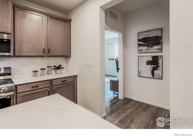 692 Galloway Dr, Johnstown, CO 80534 - kitchen featuring stainless steel appliances, dark wood-type flooring, light countertops, and decorative backsplash