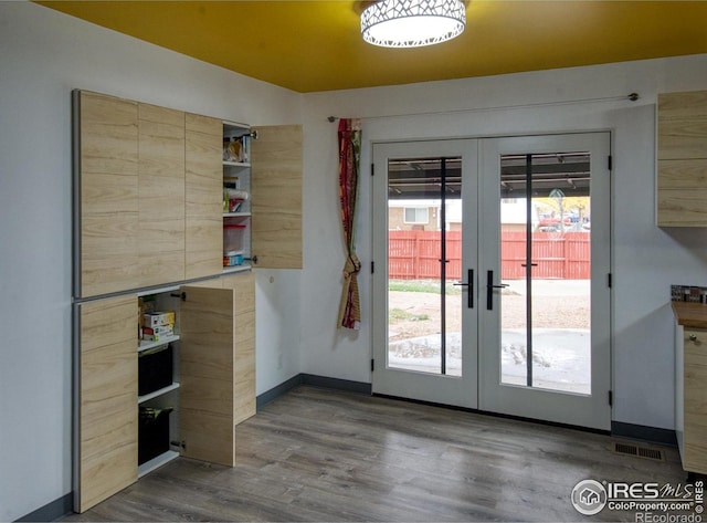 doorway with wood-type flooring and french doors