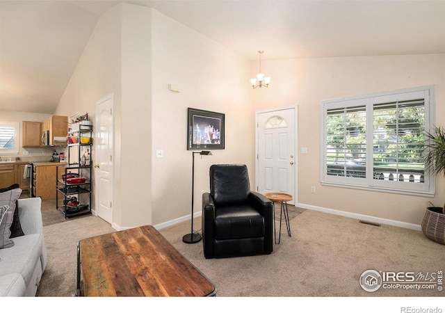 living room with an inviting chandelier, high vaulted ceiling, and light carpet