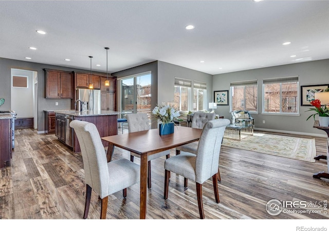 dining space with baseboards, dark wood finished floors, and recessed lighting