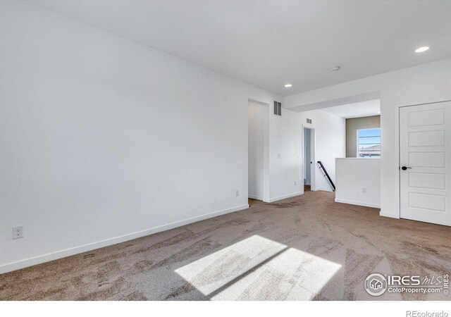 unfurnished room with carpet floors, recessed lighting, visible vents, and baseboards