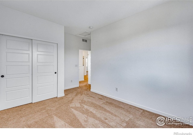 unfurnished bedroom with carpet floors, baseboards, visible vents, and a closet