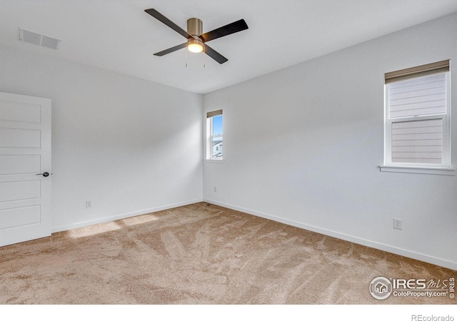empty room featuring baseboards, visible vents, ceiling fan, and carpet flooring