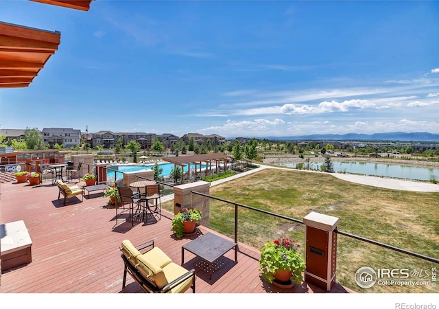 wooden deck with a water view, a residential view, and a lawn
