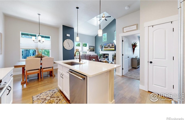 kitchen with sink, light wood-type flooring, stainless steel dishwasher, a kitchen island with sink, and white cabinets