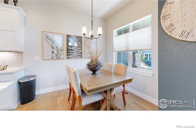 dining space with a chandelier and light hardwood / wood-style floors