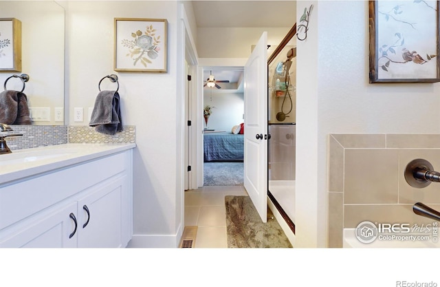 bathroom featuring vanity, tile patterned flooring, decorative backsplash, and a shower