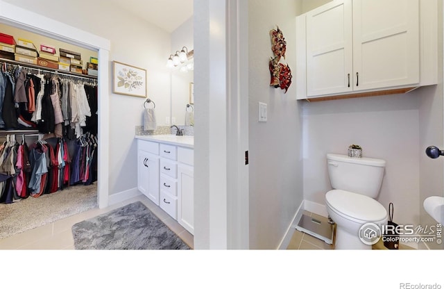 bathroom featuring tile patterned flooring, vanity, and toilet