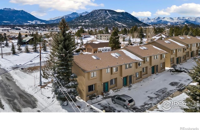 snowy aerial view with a residential view and a mountain view