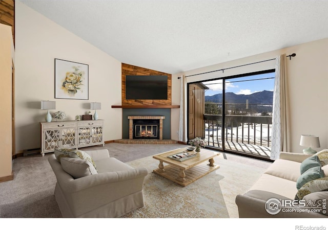 living room with lofted ceiling, carpet, a fireplace, and a textured ceiling