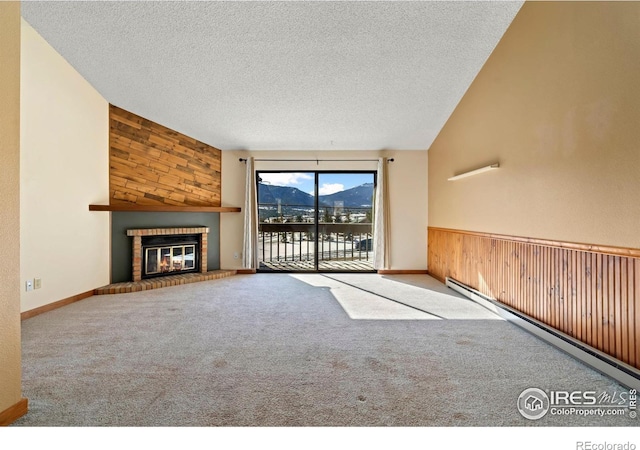 unfurnished living room featuring carpet, wood walls, and a textured ceiling