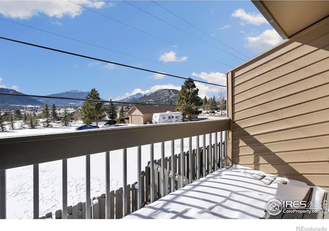 snow covered back of property featuring a mountain view