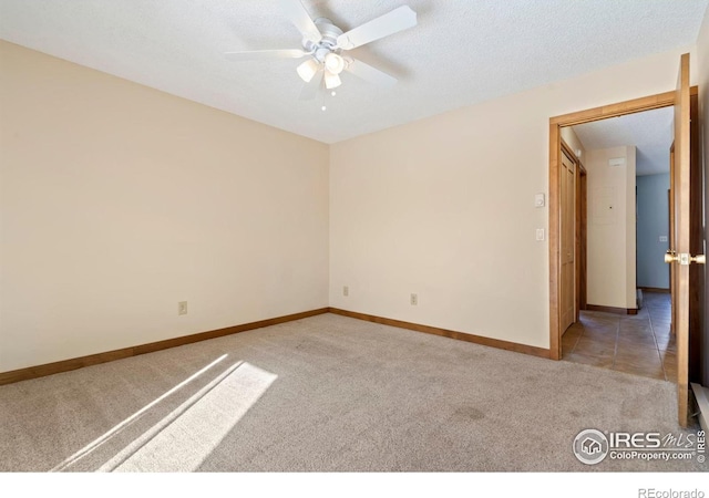 empty room with baseboards, light colored carpet, and a textured ceiling