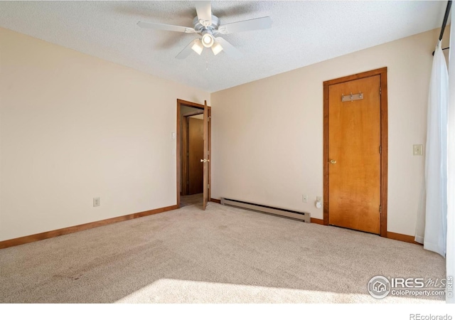 unfurnished bedroom featuring baseboards, baseboard heating, carpet flooring, and a textured ceiling