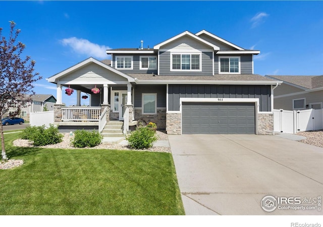 craftsman house featuring covered porch, board and batten siding, a front yard, and a gate