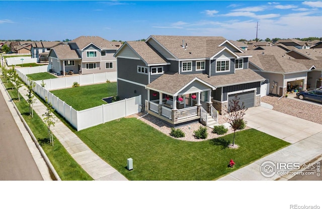 view of front of house with a residential view, concrete driveway, a front yard, a fenced backyard, and a garage